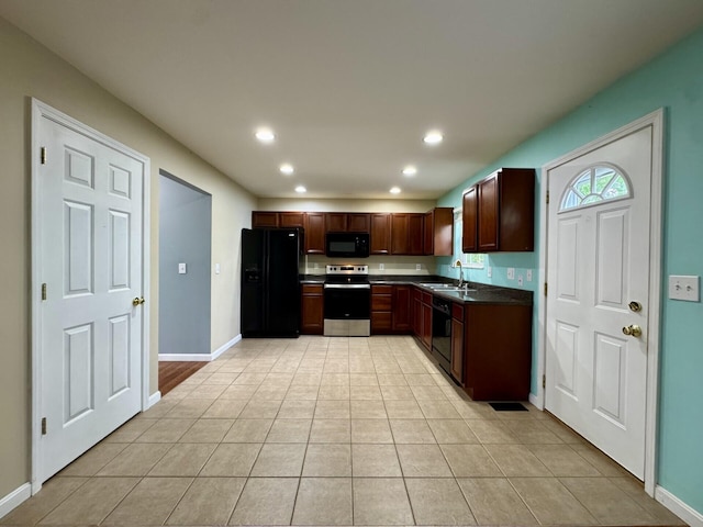 kitchen featuring black appliances, a sink, dark countertops, recessed lighting, and light tile patterned floors