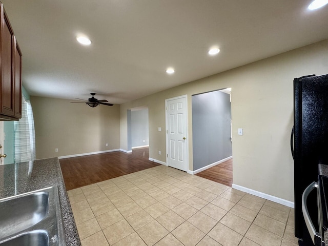 kitchen with ceiling fan, light tile patterned floors, dark countertops, recessed lighting, and freestanding refrigerator