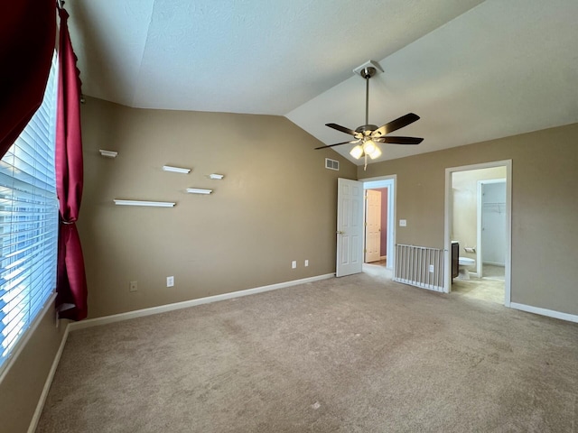 unfurnished bedroom featuring baseboards, carpet floors, vaulted ceiling, and ceiling fan