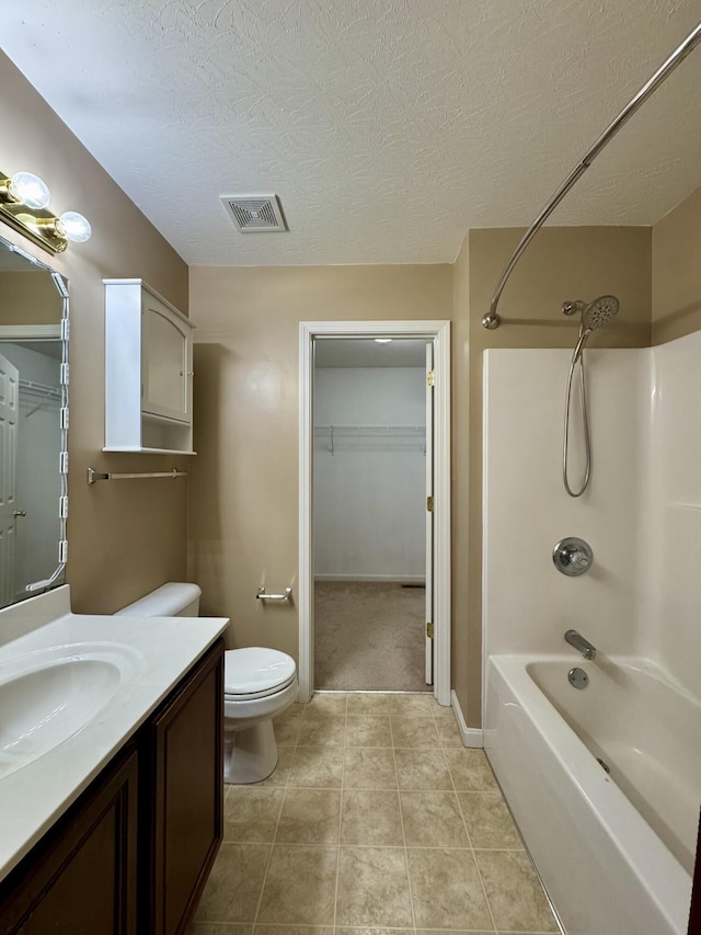full bath featuring vanity, tile patterned flooring, toilet, a textured ceiling, and washtub / shower combination