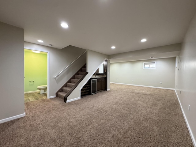 below grade area featuring light colored carpet, stairs, baseboards, and recessed lighting