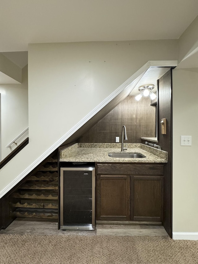 indoor wet bar with beverage cooler and baseboards