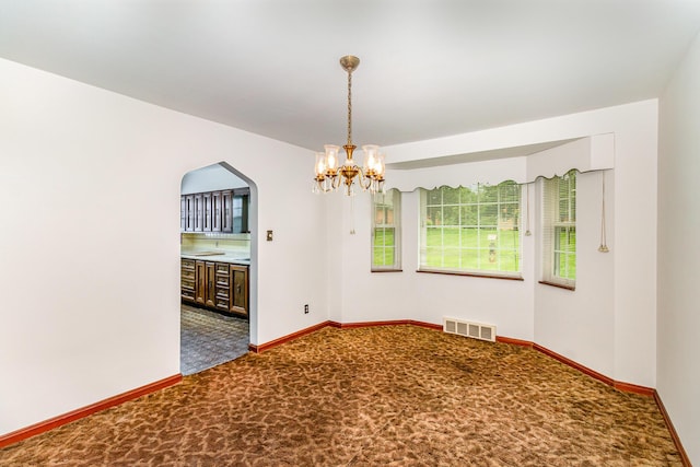 39 Buttermilk Pike, Fort Mitchell, KY 41017 - empty room featuring carpet floors, arched walkways, a chandelier, and baseboards