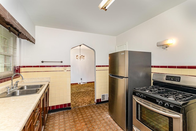 39 Buttermilk Pike, Fort Mitchell, KY 41017 - kitchen featuring appliances with stainless steel finishes, a sink, light countertops, tile walls, and wainscoting