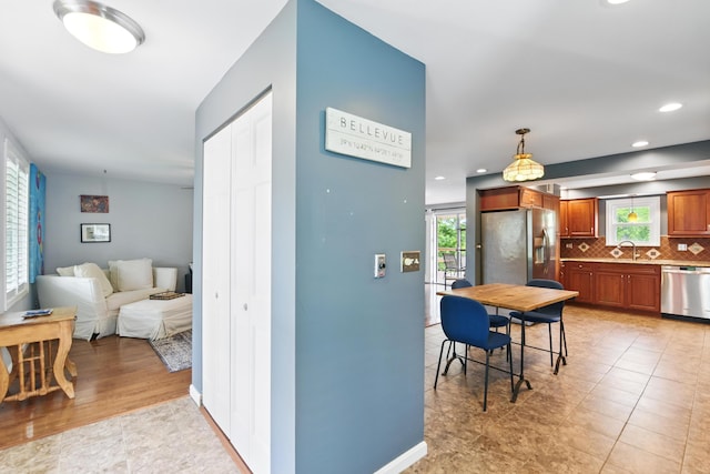 17 Harrison Ave, Bellevue, KY 41073 - kitchen with stainless steel appliances, decorative backsplash, brown cabinets, plenty of natural light, and recessed lighting