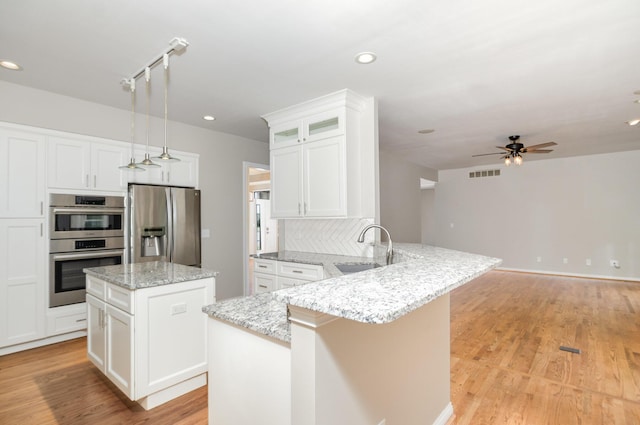 1169 Appomattox Dr, Florence, KY 41042 - kitchen featuring appliances with stainless steel finishes, a sink, a peninsula, a center island, and light wood-type flooring