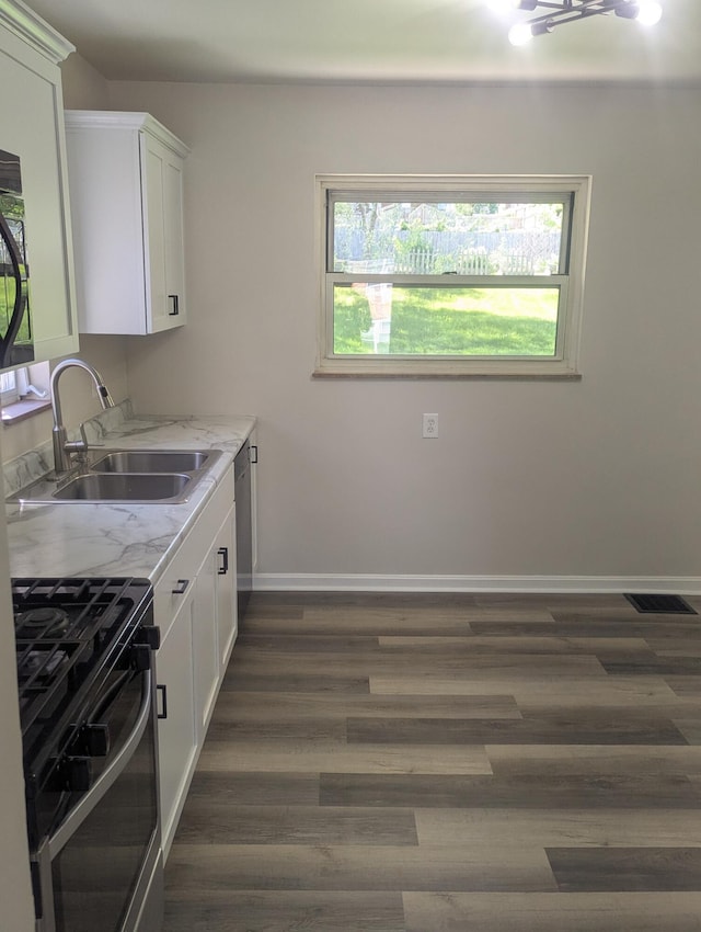 3157 Woodward St, Erlanger, KY 41018 - kitchen with gas stove, a sink, baseboards, white cabinets, and dark wood-style flooring