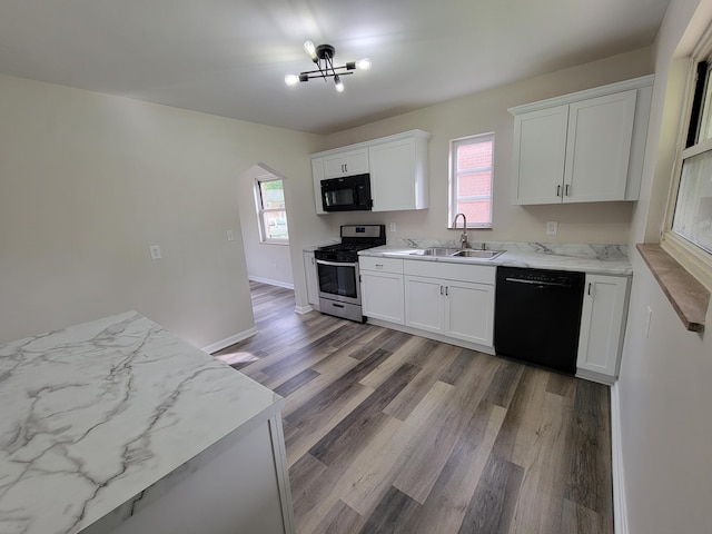 3157 Woodward St, Erlanger, KY 41018 - kitchen featuring black appliances, a sink, light wood-type flooring, white cabinets, and arched walkways
