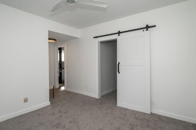 2730 Dakota Ave, Covington, KY 41015 - unfurnished bedroom with a barn door, carpet flooring, baseboards, ceiling fan, and a closet