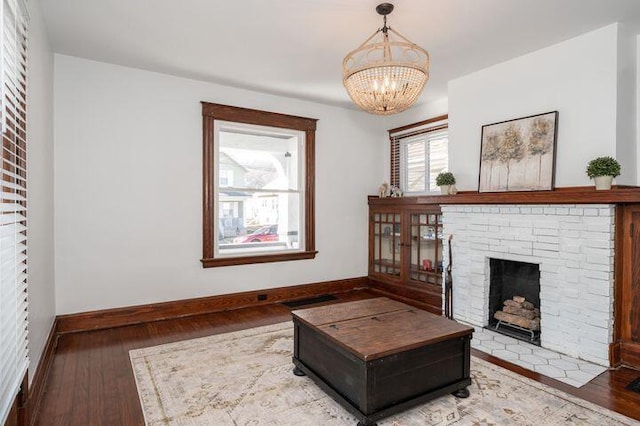2730 Dakota Ave, Covington, KY 41015 - living room featuring hardwood / wood-style floors, a brick fireplace, baseboards, and a chandelier
