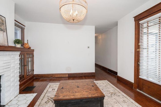 2730 Dakota Ave, Covington, KY 41015 - unfurnished living room featuring a chandelier, wood finished floors, baseboards, and a fireplace