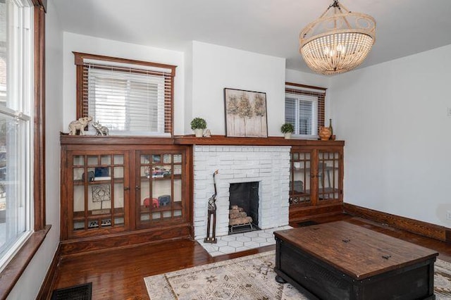 2730 Dakota Ave, Covington, KY 41015 - living room with a chandelier, wood finished floors, baseboards, and a fireplace with flush hearth