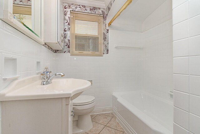 bathroom with tile walls, toilet, tile patterned floors, vanity, and shower / tub combination