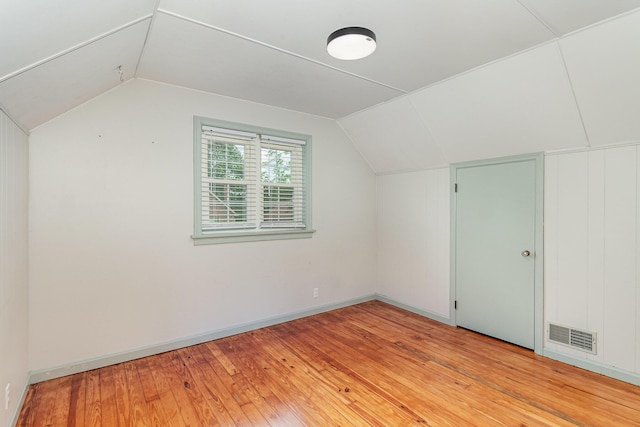 additional living space with lofted ceiling, light wood-style floors, and baseboards