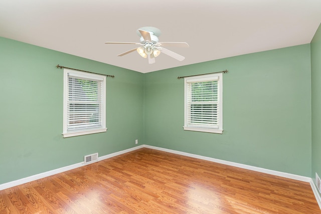 spare room featuring healthy amount of natural light, a ceiling fan, and light wood finished floors