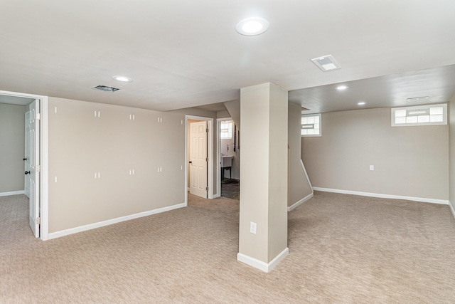 basement featuring light carpet, baseboards, and recessed lighting