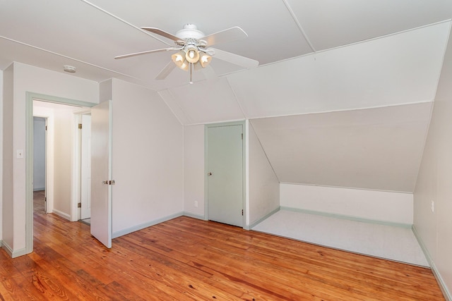bonus room featuring lofted ceiling, ceiling fan, light wood-style flooring, and baseboards