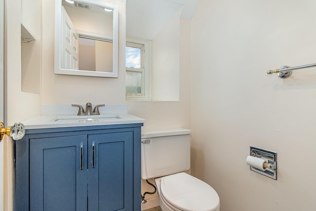 half bathroom with vanity and toilet