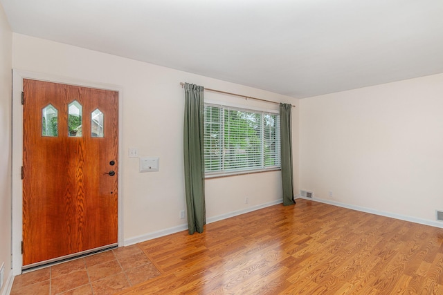 foyer with light wood finished floors and baseboards