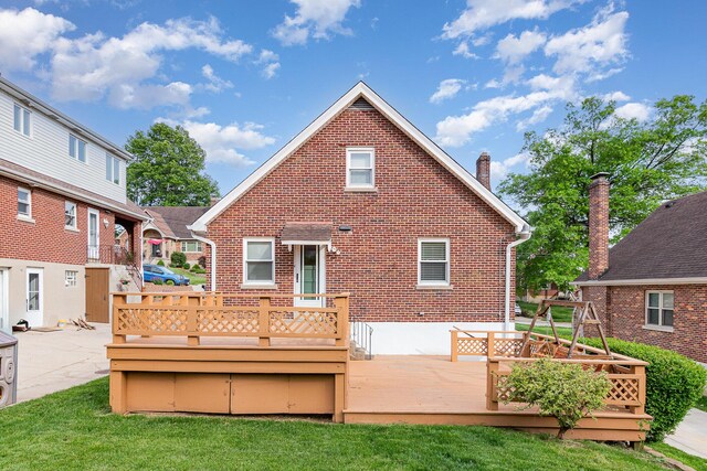 back of property featuring brick siding, a chimney, and a wooden deck
