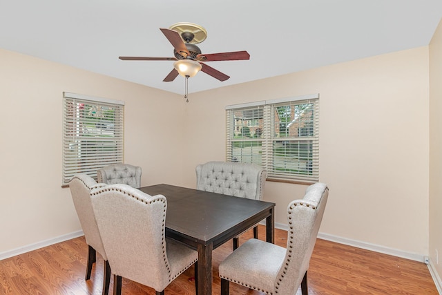 dining space featuring ceiling fan, light wood-style floors, and baseboards