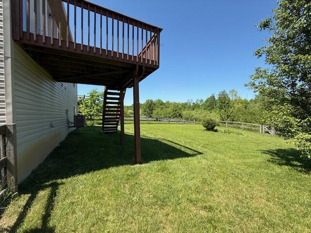 view of yard featuring stairway, a wooden deck, and central AC unit