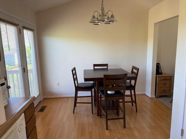 dining space with a chandelier, light wood-style floors, and baseboards