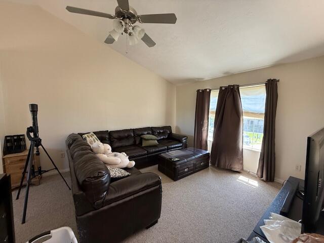 carpeted living room with vaulted ceiling and ceiling fan