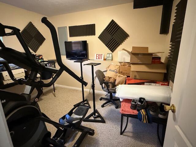 exercise room with carpet flooring and baseboards