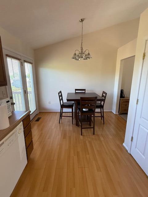 dining area featuring light wood-style floors, a chandelier, and baseboards