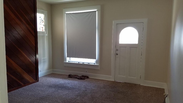 carpeted foyer with baseboards