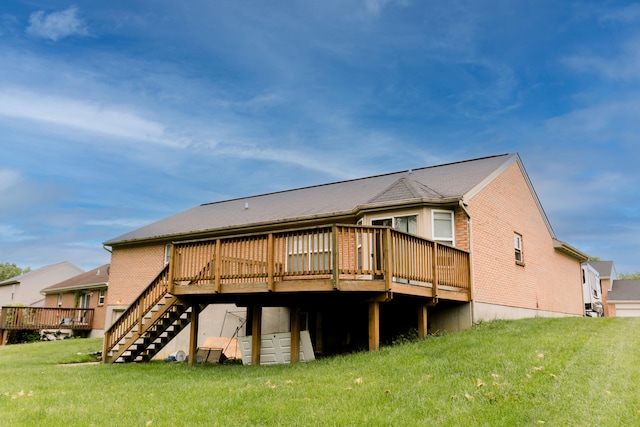 rear view of property featuring a deck, a yard, stairway, and brick siding