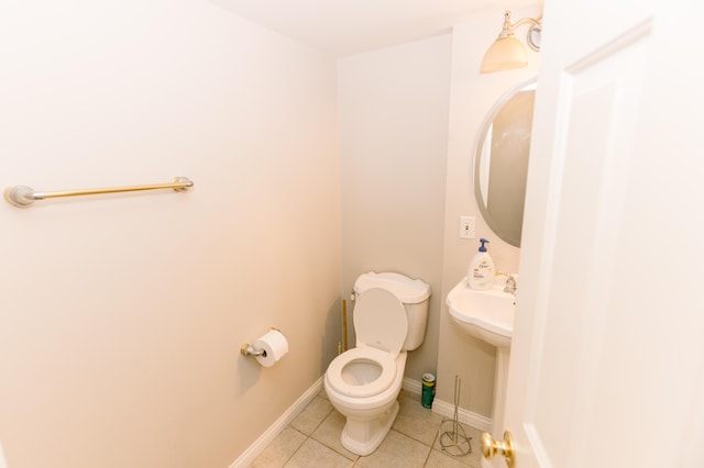 half bathroom featuring tile patterned floors, toilet, and baseboards