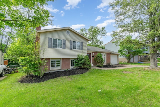 tri-level home with a garage, driveway, a front lawn, a chimney, and brick siding