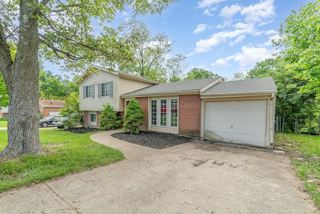 split level home with concrete driveway, brick siding, an attached garage, a front yard, and a shingled roof