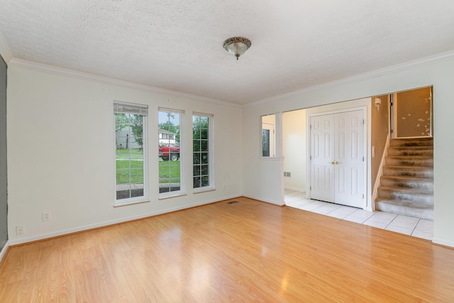 unfurnished room featuring wood finished floors, stairway, ornamental molding, and baseboards