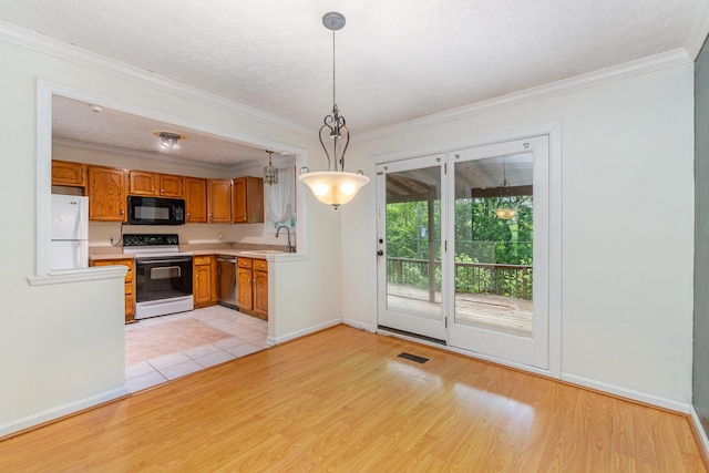 kitchen with white appliances, a sink, light countertops, light wood finished floors, and crown molding