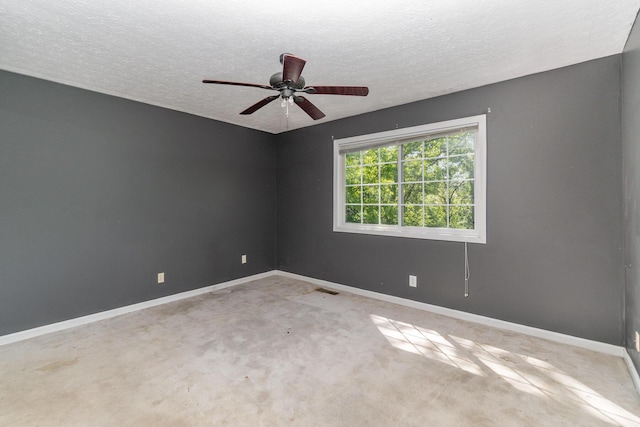 carpeted empty room with baseboards, a textured ceiling, and a ceiling fan