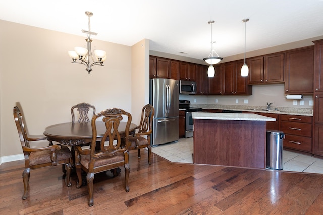 567 Riverpointe Dr Unit 11, Dayton, KY 41074 - kitchen featuring stainless steel appliances, a chandelier, a kitchen island, a sink, and dark brown cabinetry