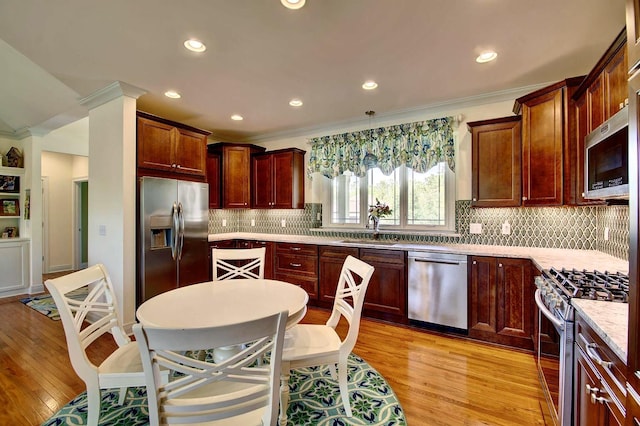 3257 Ivy Ridge Dr, Taylor Mill, KY 41015 - kitchen with appliances with stainless steel finishes, ornamental molding, a sink, light wood-style floors, and decorative backsplash