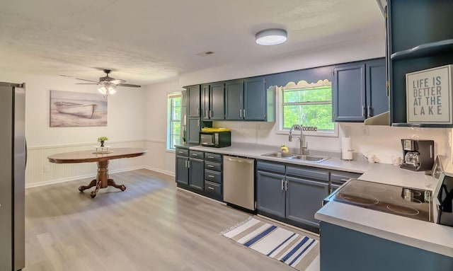 6740 Wisdom Dock Rd, Albany, KY 42602 - kitchen featuring stainless steel dishwasher, a sink, healthy amount of natural light, light countertops, and wainscoting