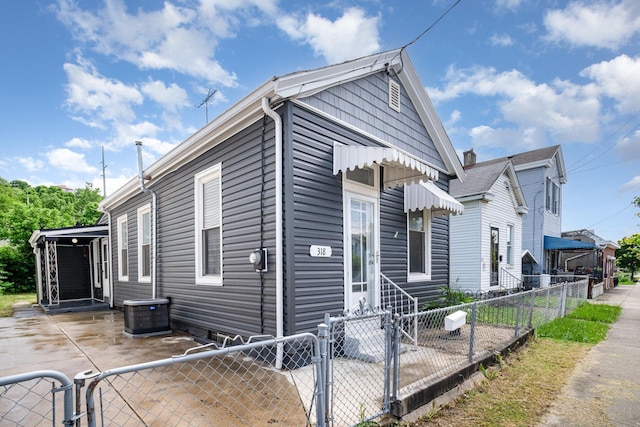 view of front of home with a gate, a fenced front yard, central air condition unit, and entry steps