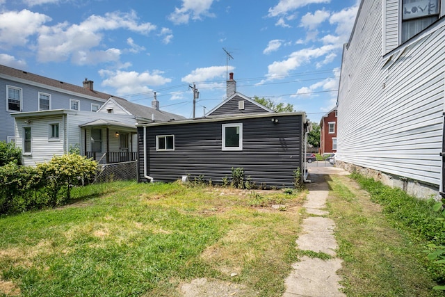 rear view of house featuring a yard