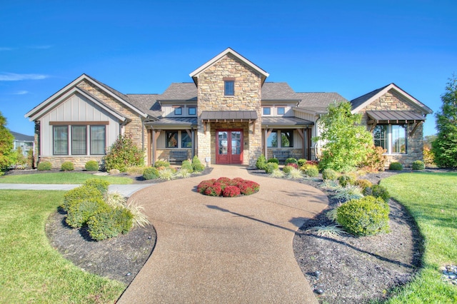 2422 Arezzo St, Covington, KY 41017 - craftsman-style house featuring stone siding, a standing seam roof, french doors, and a front lawn