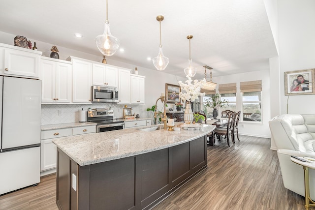 10988 Dairybarn Ln, Alexandria, KY 41001 - kitchen with appliances with stainless steel finishes, white cabinets, decorative backsplash, wood finished floors, and recessed lighting