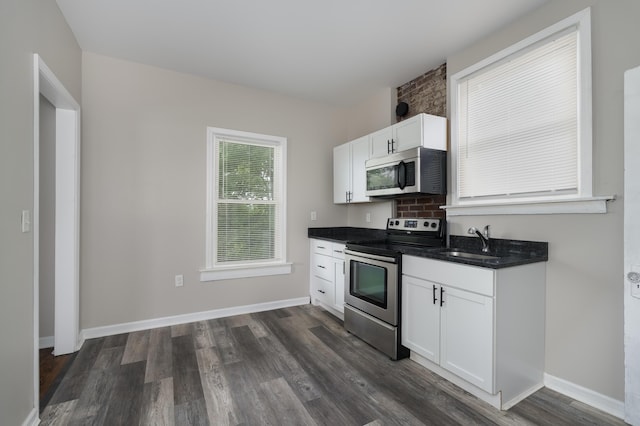 2789 Madison Ave, Covington, KY 41015 - kitchen featuring stainless steel appliances, dark wood finished floors, white cabinetry, and a sink