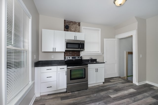 2789 Madison Ave, Covington, KY 41015 - kitchen featuring appliances with stainless steel finishes, a sink, dark countertops, and white cabinets