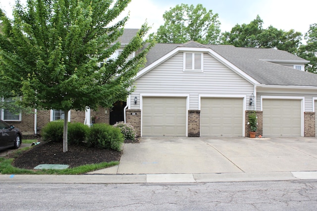 515 Telescope Vw Unit 103, Wilder, KY 41076 - view of front facade with brick siding, a garage, driveway, and roof with shingles