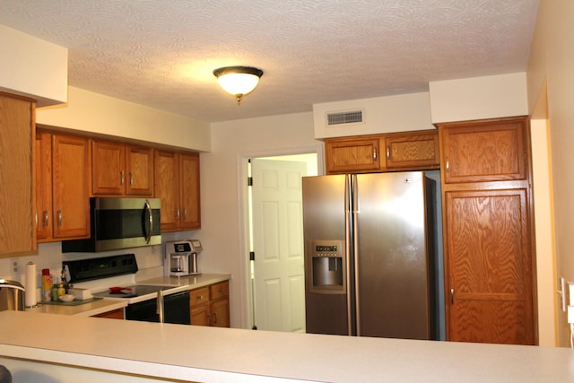 515 Telescope Vw Unit 103, Wilder, KY 41076 - kitchen featuring stainless steel appliances, brown cabinetry, and light countertops