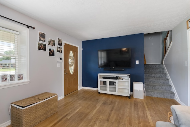 3350 Redbud Ct, Erlanger, KY 41018 - unfurnished living room featuring stairway, healthy amount of natural light, wood finished floors, and baseboards